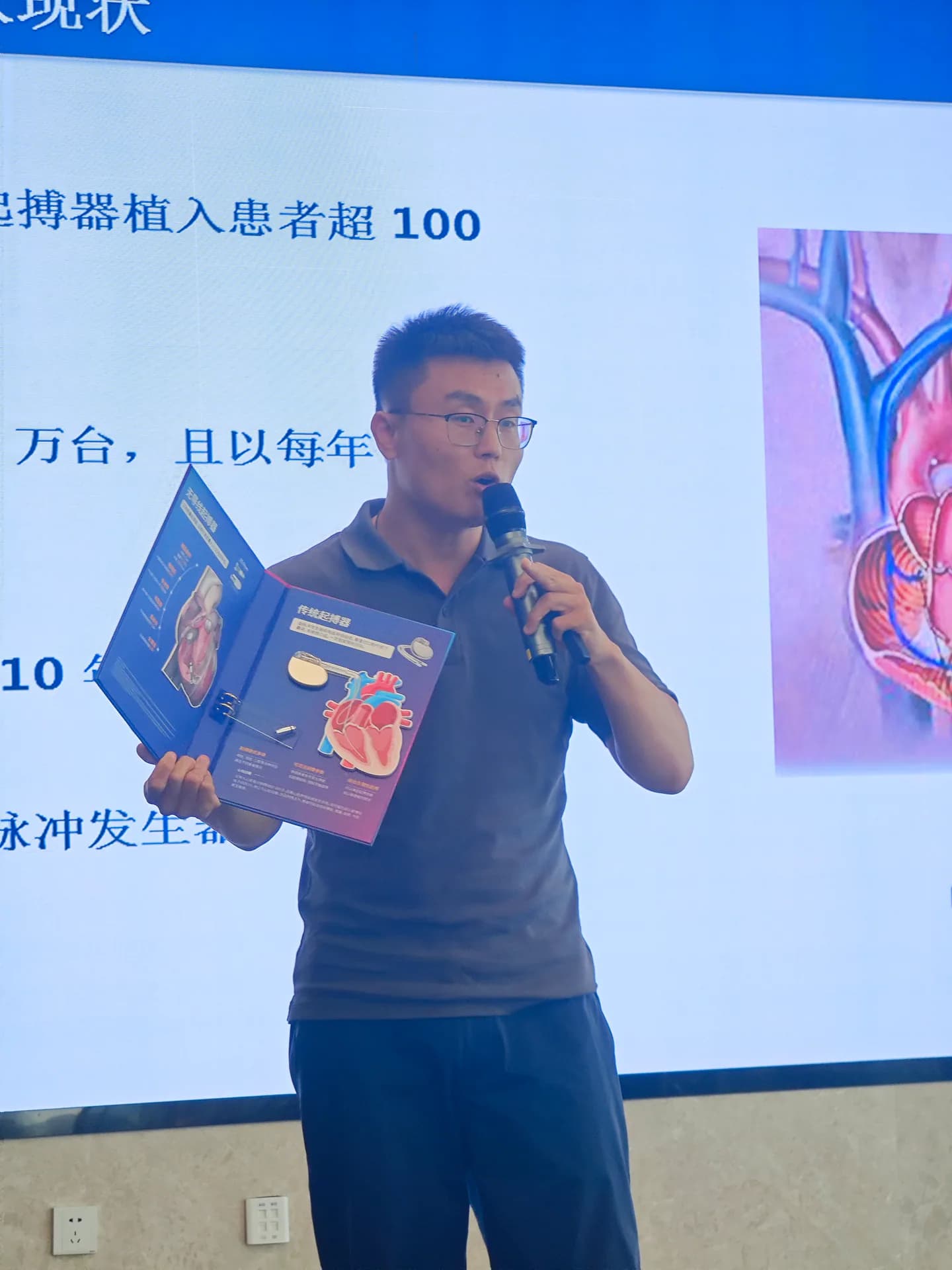 讲师手持医疗产品资料进行现场展示
